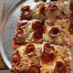 M&M Scotto's Pizzeria - Sicilian style pizza with two pieces already removed. Delicious!!