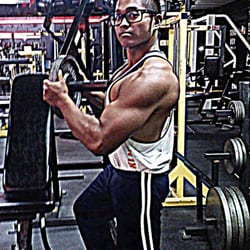Asylum Gym - Mark Salameda at the Asylum Gym loading a plate on the iso decline chest machine. Former employee and lifelong member.
