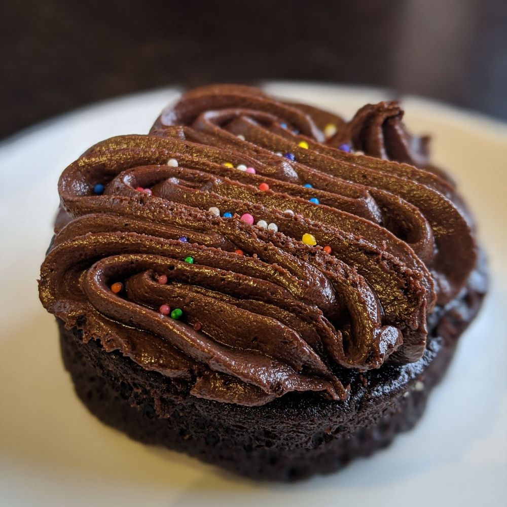 Tan Coffee - a chocolate cupcake with chocolate frosting and sprinkles - Coffee & Tea Near Me - Kentville, Nova Scotia Tan Coffee - a chocolate cupcake with chocolate frosting and sprinkles - Coffee & Tea Near Me - Kentville, Nova Scotia