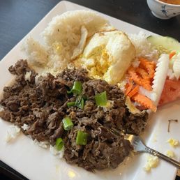 Broken rice platter with grilled beef, fried egg, rice and veggies.