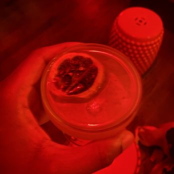 Zig Zag - a person holding a glass with a grapefruit in it - Cocktail Bars Near Me - Brooklyn, New York