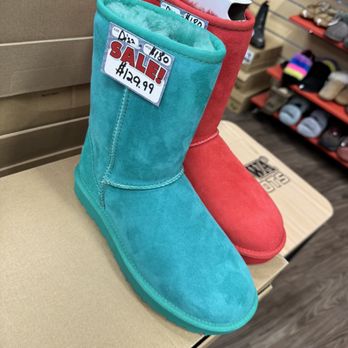 Boot World - Boot sale - Turquoise and red winter boots are displayed on a store counter, with sale tags showing prices. The boots are lined with faux fur and are part of a footwear sale. - Shoe Stores Near Me - Oceanside, California