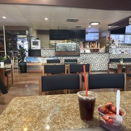 Cafe seating area and counter, iced americano, and açaí bowl Cafe seating area and counter, iced americano, and açaí bowl