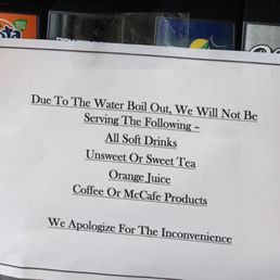 a sign in front of a coffee machine a sign in front of a coffee machine