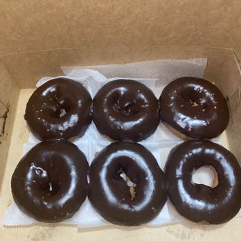 Allegretti's Bakery - Six chocolate-glazed donuts are arranged in a cardboard bakery box with parchment paper lining. - Bakeries Near Me - Norridge, Illinois