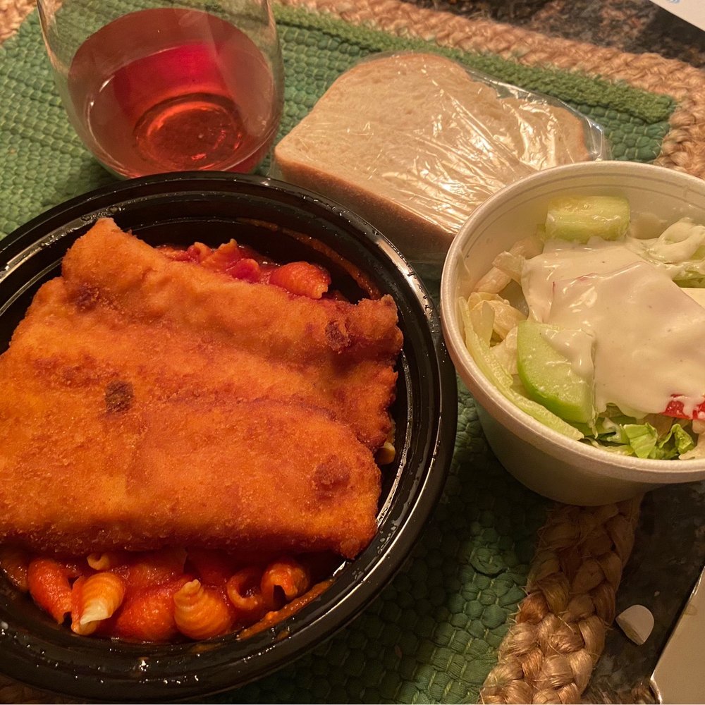 To-Go Plain fish dinner served over shells and sauce, with a side salad and Italian bread.