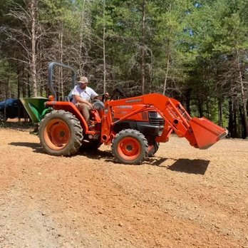 Triad Land Construction - a man driving a tractor - Landscaping Near Me Triad Land Construction - a man driving a tractor - Landscaping Near Me