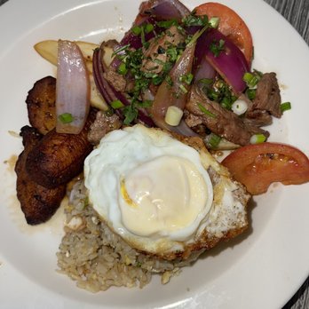 Ceviche 19 - Lomo Fusion - Fried rice & fries topped with their stir fried beef , red onions, & tomatoes. Added an extra fried egg & more plantains! - Peruvian Near Me - Anaheim, California
