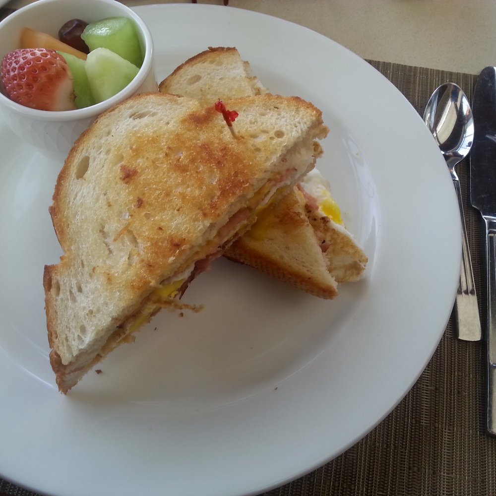 Sage Cafe - Breakfast special 1/22/15. Grilled cheese with ham, 2 over medium eggs in buttered sourdough toasted bread with a cup of fruit. - American Near Me - Lakeside, California