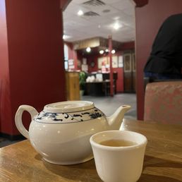 a tea pot and cup on a table a tea pot and cup on a table