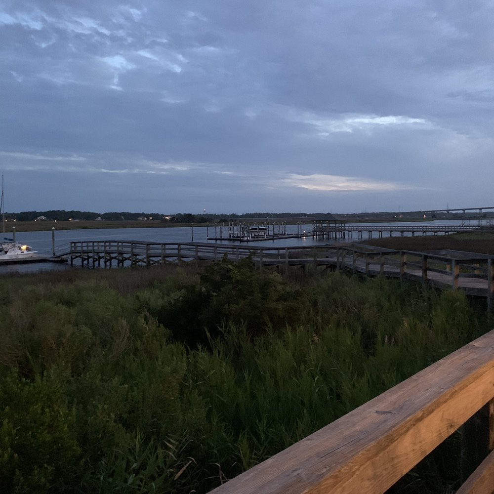 Rusty Hooks Dockside Grill - a view of a dock at dusk - Seafood Near Me - Southport, North Carolina Rusty Hooks Dockside Grill - a view of a dock at dusk - Seafood Near Me - Southport, North Carolina