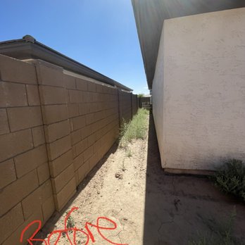 Roberts Landscaping Services - a side yard with a brick wall - Landscaping Near Me