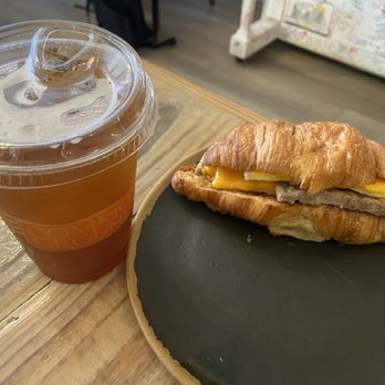 Common Grounds Brew & Roastery - Coffee lemonade with lavender and sausage egg and cheese croissant with honey drizzle - Coffee & Tea Near Me - Lake Worth, Florida