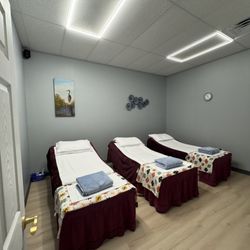 Spring Health Massage Spa - Peaceful group massage room with three neatly prepared tables, perfect for friends or family sessions in a relaxing environment.