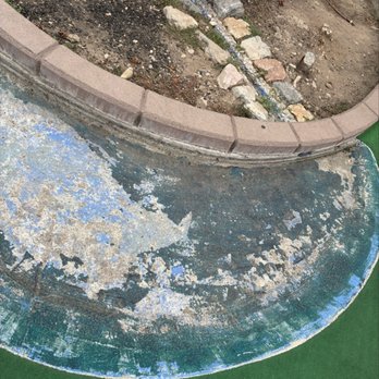 Scratch Mini Golf Formerly Cascade Mini Golf - You can see where water once used to be - The image shows a circular surface with peeling paint, revealing multiple layers of color underneath, and a green border along the edge. Behind this surface, there is a garden area with soil, rocks, and a curved brick border. The garden contains soil with scattered rocks and a small section of bricks arranged in a border or edging. The scene appears to be part of an outdoor landscaping or garden setup, with construction or renovation elements visible. - Golf Near Me - Orem, Utah