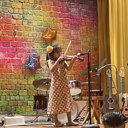 Encore Music & Performing Arts - A child performs her violin recital at the Encore Spring Costume Concert
