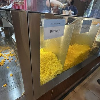Garrett Popcorn Shops - Self-serve popcorn station with labeled sections for Buttery and CheeseCorn flavors, featuring yellow popcorn. - Popcorn Shops Near Me - Chicago, Illinois