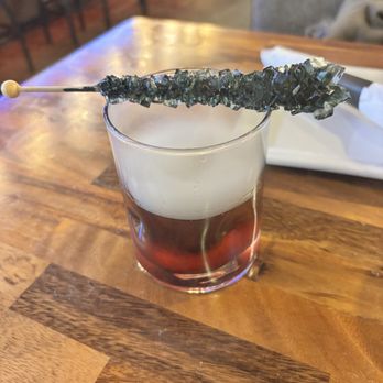 Rockwood - Coal for Christmas cocktail with rock candy garnish - Sports Bars Near Me - Gainesville, Virginia