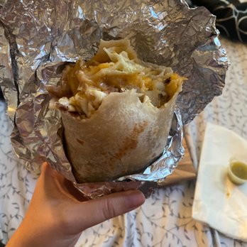 El Pique - a person holding a burrito wrapped in foil - Mexican Near Me - Springfield, Oregon
