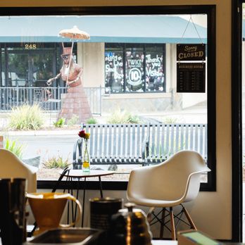 Cosmic Bloom Coffee - a woman holding an umbrella - Coffee & Tea Near Me - Vista, California