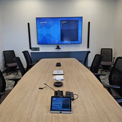 Premier AV Integration - Medium conference room with 86" display, table top microphones and elegant touch screen for meeting control.