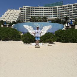 Me standing in front of the Eagles wings on the beach in front of the Live Aqua Resort .