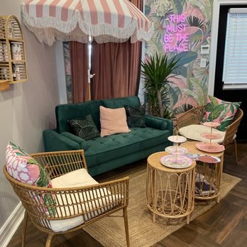 BesTea by Hitch - a living room with a green couch, wicker chairs, and an umbrella - Coffee & Tea Near Me - Babylon, New York