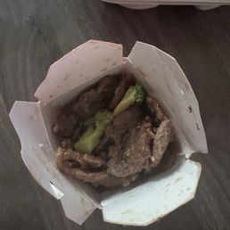Box full of beef with two pieces of broccoli