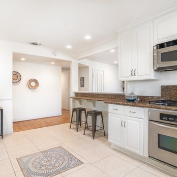 Custom Painting & Decorating - a kitchen with white cabinets and stainless steel appliances - Painters Near Me - Anaheim, California