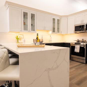 Galleria Design Studio - This quick-ship kitchen cabinet line offers a custom feel with stylish design elements like glass inserts, a stunning waterfall quartz count - Cabinetry Near Me - Glenview, Illinois