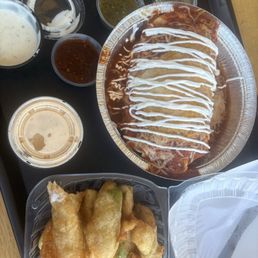 Three Amigos breakfast burrito with a side order of fried avocado and different salsas and sauces.