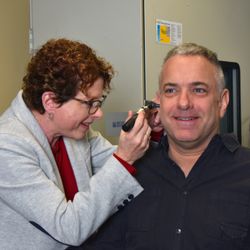 Hearcare Audiology - Hearing Instrument Specialist Jodi Weber inspecting a patient's ear.