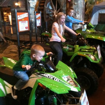 Bass Pro Shops - 4-wheelers on display, waterfall with water wheel in background - Guns & Ammo Near Me - Independence, Missouri Bass Pro Shops - 4-wheelers on display, waterfall with water wheel in background - Guns & Ammo Near Me - Independence, Missouri