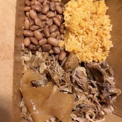 A meal box of Carnitas with rice and beans