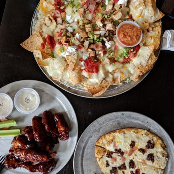 Plaza Bar - a plate of nachos, a plate of chicken wings, and a plate of pizza - Bars Near Me - Olympic Valley, California