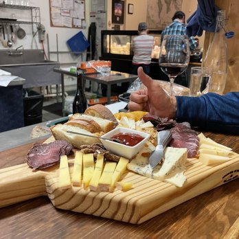 Ten:One Artisanal Cheese Shop - a man holding a glass of wine - Cheese Shops Near Me - Denton, Texas Ten:One Artisanal Cheese Shop - a man holding a glass of wine - Cheese Shops Near Me - Denton, Texas