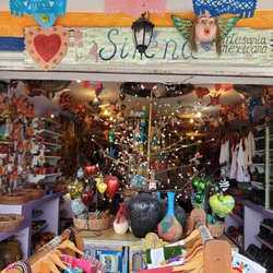 Sirena - Beautiful clothes and crafts displayed at store front.