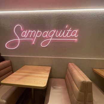 Sampaguita - Small seating area off to one side perfect for two to four people with neon signage. More tables and chairs on other side. - Ice Cream & Frozen Yogurt Near Me - Orlando, Florida Sampaguita - Small seating area off to one side perfect for two to four people with neon signage. More tables and chairs on other side. - Ice Cream & Frozen Yogurt Near Me - Orlando, Florida