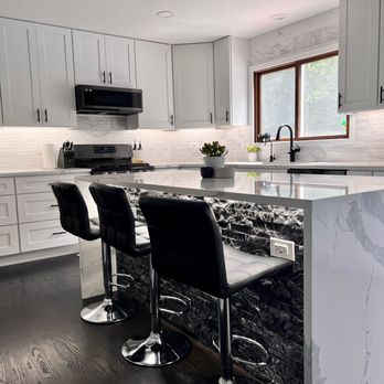 IVK Group - a kitchen with a marble island and bar stools - General Contractors Near Me IVK Group - a kitchen with a marble island and bar stools - General Contractors Near Me
