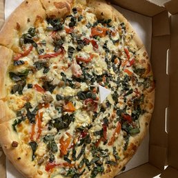 a whole pizza in a box - A pizza topped with cheese, red and green peppers, herbs, and possibly sausage, in a pizza box.