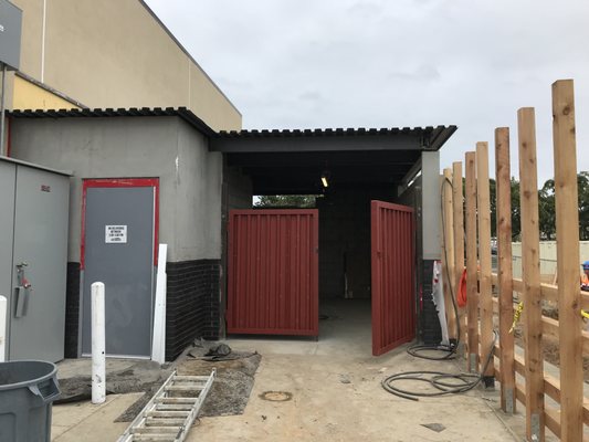 Roof and doors installed on a dumpster enclosure