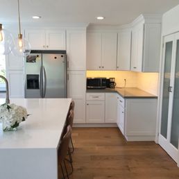 a kitchen with white cabinets and white countertops
