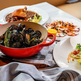 Toulouse Cafe and Bar - Mussels in a red pot served with French plates and glasses of white and rosé wine. - French Near Me - Houston, Texas Toulouse Cafe and Bar - Mussels in a red pot served with French plates and glasses of white and rosé wine. - French Near Me - Houston, Texas