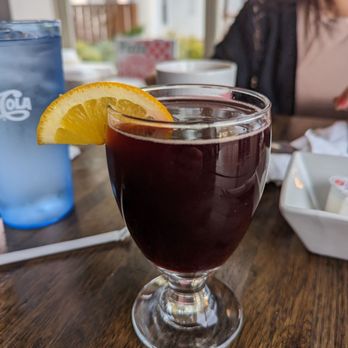 Mama Lor's Cafe - a woman sitting at a table with a drink - Cafes Near Me - Webster, New York Mama Lor's Cafe - a woman sitting at a table with a drink - Cafes Near Me - Webster, New York