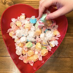 a heart shaped bowl filled with candy