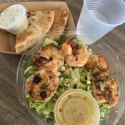 Shrimp Romaine Salad with Pita and Tzatziki on the side and a Complimentary Water Cup.