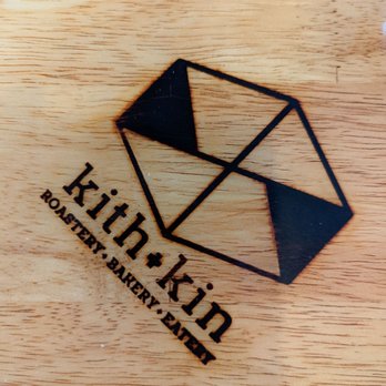 Kith + Kin Roasting - a wooden cutting board with a logo on it - Coffee & Tea Near Me - Artesia, New Mexico