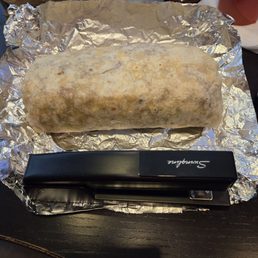 Huge bacon, egg, cheese and potato breakfast burrito. Stapler for scale. Huge bacon, egg, cheese and potato breakfast burrito. Stapler for scale.