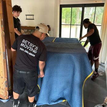 Betsy's Moving - We take great care in every job. Here the guys are wrapping a beautiful grand piano and getting it ready for transport. - Movers Near Me