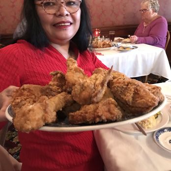 Legacy Kansas - a woman holding a plate of fried chicken - Comfort Food Near Me - Abilene, Kansas